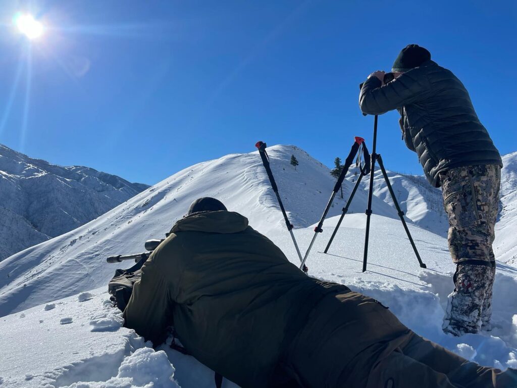 two hunters field testing rifles in the snow